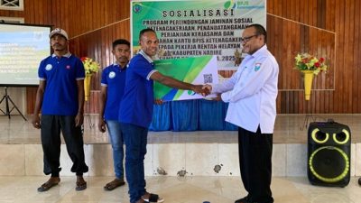 (Kepala Dinas Perikanan menyerahkan BPJS Ketenagakerjaan secara simbolis kepada salah satu perwakilan nelayan)