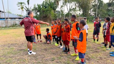 (Yahya Sosomar atau Coach Yaso memberikan arahan kepada anak-anak SSB All Star Nabire saat latihan sepak bola di lapangan SMP Negeri 3 Nabire. Melalui pembinaan sejak usia dini, mantan striker Persinab ini berupaya menanamkan disiplin dan mengembangkan bakat sepak bola generasi muda Papua)