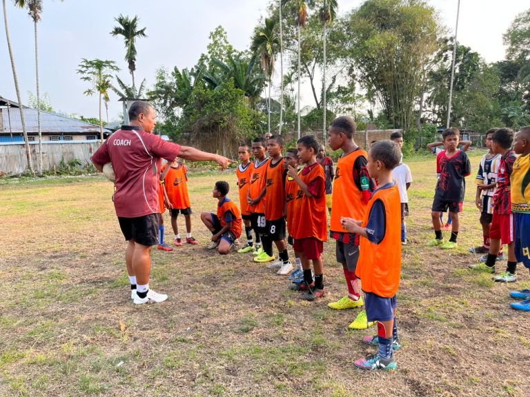(Yahya Sosomar atau Coach Yaso memberikan arahan kepada anak-anak SSB All Star Nabire saat latihan sepak bola di lapangan SMP Negeri 3 Nabire. Melalui pembinaan sejak usia dini, mantan striker Persinab ini berupaya menanamkan disiplin dan mengembangkan bakat sepak bola generasi muda Papua)