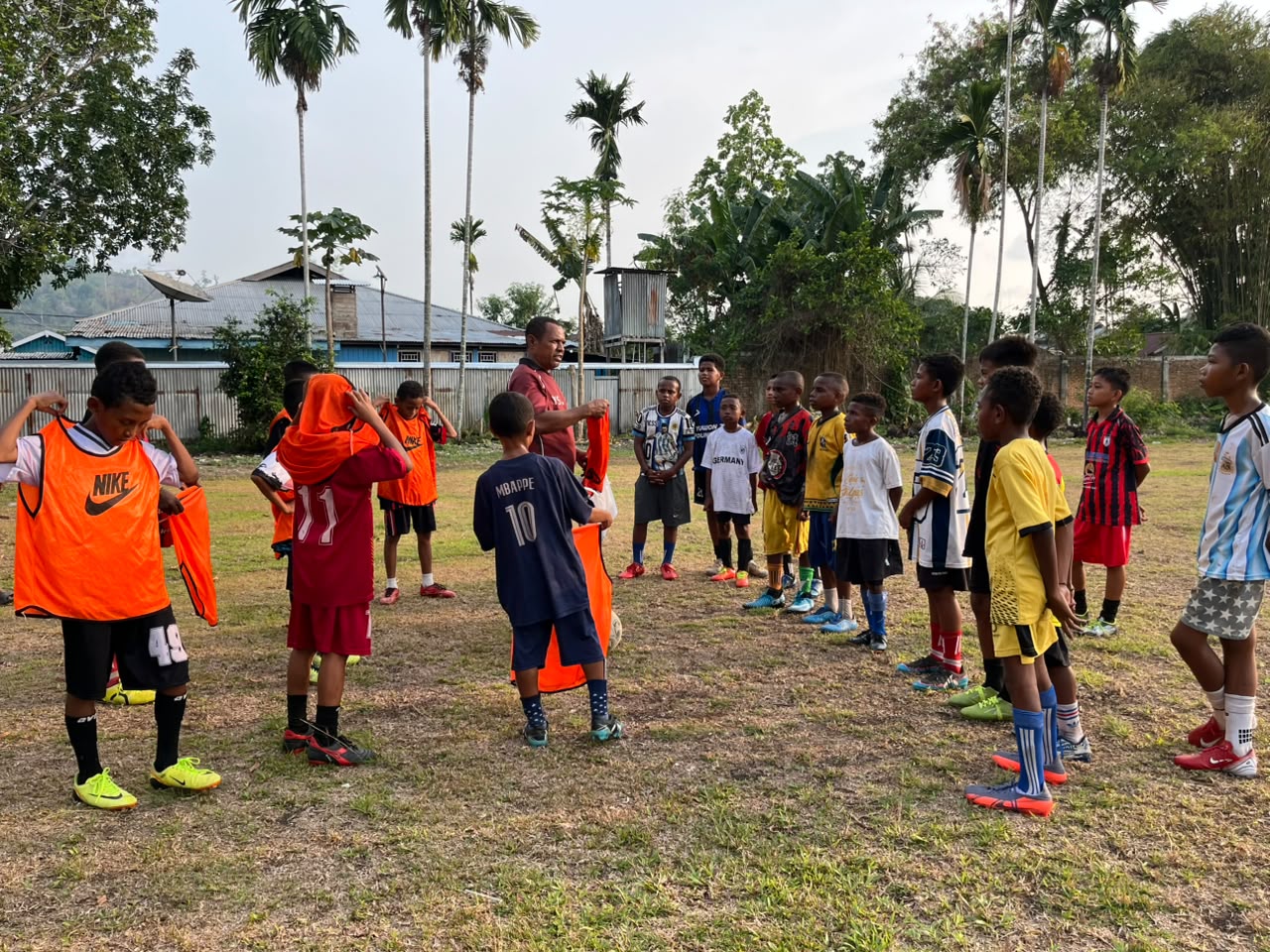 (Coach Yaso mengumpulkan para pemain SSB All Star Nabire sebelum latihan. Ia membina sekitar 50 anak secara gratis sebagai upaya memberi ruang bagi generasi muda untuk mengembangkan bakat dan mengejar mimpi di dunia sepak bola)